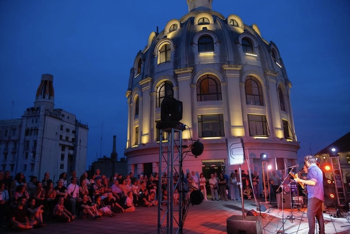 Show en vivo en una terraza al atardecer junto a una cúpula histórica