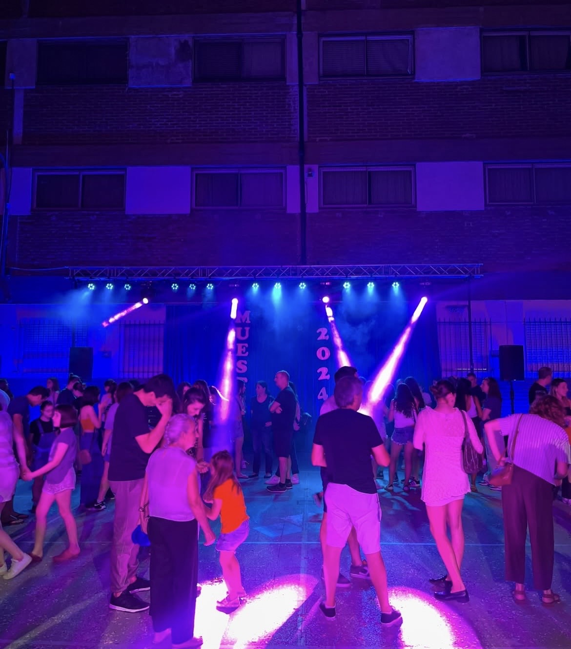 Pista de baile con luces móviles violeta en un evento al aire libre